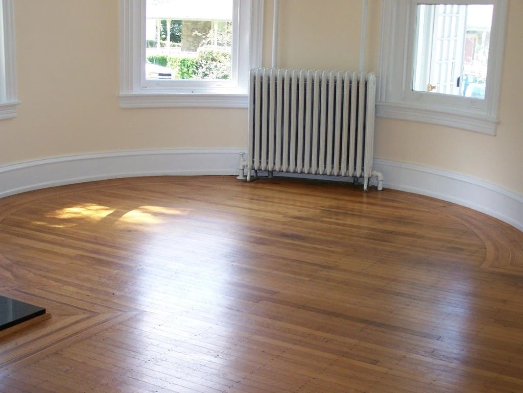 Empty bright room with refinished hardwood flooring